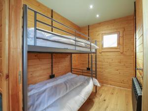 a bedroom with two bunk beds in a wooden wall at Otter's View in Oakham