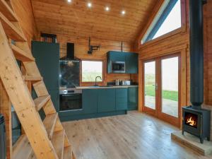 a kitchen with a stove and a staircase in a cabin at Squirrel's Nest in Oakham