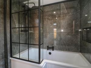 a bathroom with a tub and a glass shower at Squirrel's Nest in Oakham