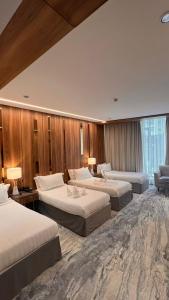 a hotel room with three beds in a room at فندق ماسة المشاعر الفندقية in Makkah