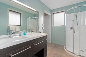 a bathroom with a sink and a shower at Luxury Lake Hood Holiday Home in Wakanui +16 photos