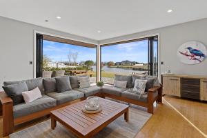 a living room with a couch and a table at Luxury Lake Hood Holiday Home in Wakanui