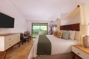 a bedroom with a bed and a desk and a television at Villa Premiere Boutique Hotel & Romantic Getaway - Adults Only in Puerto Vallarta