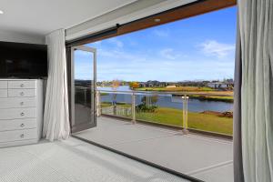 a room with a large window with a view of the water at Luxury Lake Hood Holiday Home in Wakanui