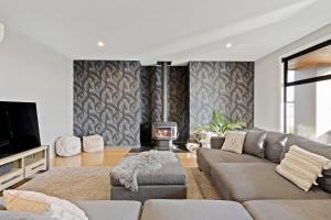 a living room with a couch and a fireplace at Waterfront Lake Hood Luxury in Wakanui