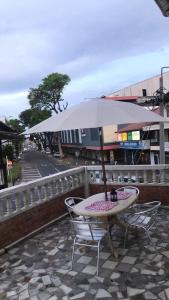 een tafel en stoelen met een parasol op een stoep bij HotelMidnight78 in Paramaribo