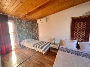 sypialnia z 2 łóżkami i drewnianym sufitem w obiekcie Heart of Old Tbilisi Apartments w mieście Tbilisi City