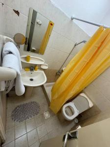 a bathroom with a yellow shower curtain and a sink at Studio in Fujairah,CIT&SEA view in Fujairah