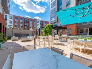 a patio with a table and chairs and an umbrella at Luxury 2-Bed 2 Bath Apartment in King of Prussia