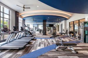 a gym with a lot of treadmills and machines at Luxury 2-Bed 2 Bath Apartment in King of Prussia