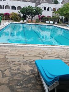 a large swimming pool with a bench next to a building at Studio Leliya in Malindi