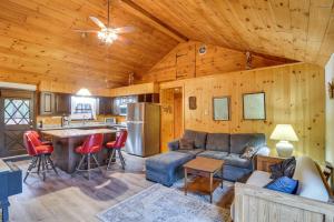 a living room with a couch and a kitchen at Cozy Thompson Lake Cabin with Boat Dock and Launch 