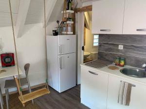 a kitchen with a white refrigerator and a sink at Studio de l’embarcadère in Terre-de-Haut