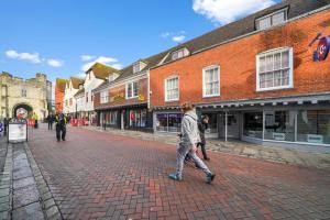 a man walking down a brick street in a town at Ideal duplex in Canterbury - Sleeps 6 in Canterbury