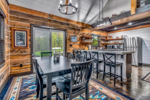 una cucina con pareti in legno, tavolo e sedie di Rustic Hideaway sleeps 4 Hot tub a De Soto