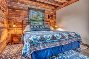 1 dormitorio con 1 cama y pared de madera en Rustic Hideaway sleeps 4 Hot tub, en De Soto