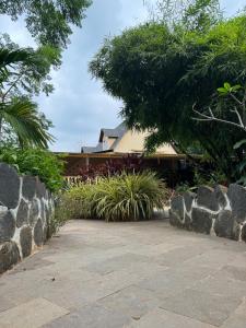 a garden with rocks and plants and a house at Chikoo Farm inn in Bangalore