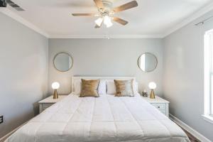 a bedroom with a large white bed with two mirrors at Modern Escape Cali King Beds EV Chargers Available in Lutz +23 photos