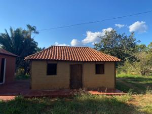 uma pequena casa com telhado de azulejo vermelho em Espaço Amainar em Sobradinho