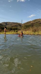 a man and a woman standing in a body of water at Espaço Amainar in Sobradinho +1 photo