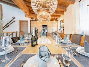 une table à manger avec des verres à vin et un lustre dans l'établissement Wagrainer TauernLodge 3B, à Wagrain