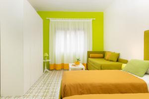 um pequeno quarto com 2 camas e um sofá em Sunny Flat free parking em Sorrento