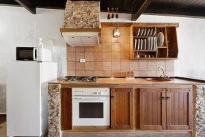 a kitchen with a stove and a white refrigerator at Apartamentos Trebol in Mocanal