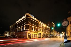 a building on a city street at night with traffic at Hotel Covington Cincinnati Riverfront in Covington