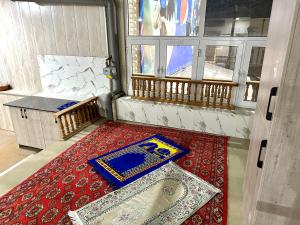 Habitación con alfombra en el suelo y ventana en MIRKA HOSTEL, en Samarkand