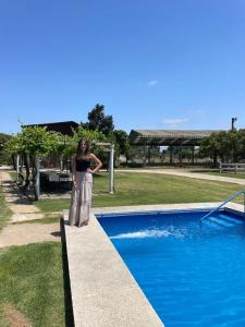 a woman standing next to a swimming pool at Texas Limache in Limache