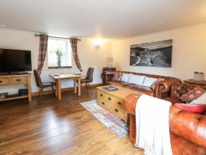 a living room with a couch and a tv at Kerrowdown Mill in Inverness