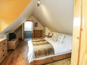 1 dormitorio con 1 cama blanca y TV en Kerrowdown Mill en Inverness