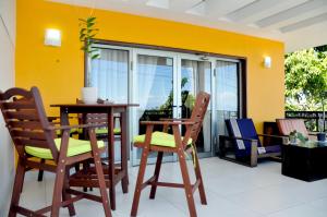 a room with a table and chairs and a yellow wall at Allamanda Hotel in Port-au-Prince