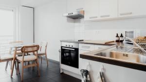 een witte keuken met een wastafel en een tafel bij Studio Saint-Martin in Tournai