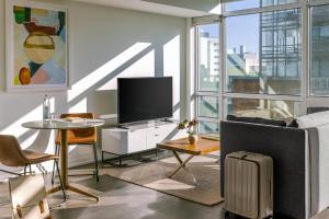 a living room with a television and a couch and a table at Sonder at The Liberty in Toronto