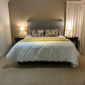 1 dormitorio con 1 cama blanca grande y 2 lámparas en 741 Tetra Self Catering Accommodation en Pretoria