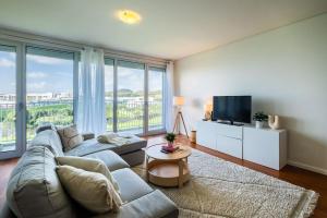a living room with a couch and a tv at Quiet & Comfy Azorean Sapphire in Fajã de Baixo