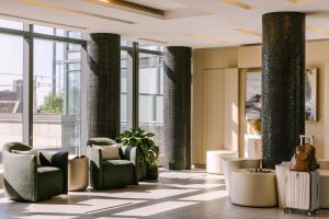 a lobby with chairs and tables and windows at Sonder at The Liberty in Toronto