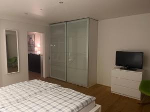 a bedroom with a bed and a television in it at Tritt ein bring Glück herein - Exquisite 75 qm - Messenähe - Parkplatz - Flughafennähe in Düsseldorf