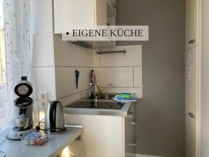 a small kitchen with a sink and a microwave at Krabbe Nordsee Apartment 2, ideal für Paare, kostenfreier Parkplatz, 2 Hunde willkommen, am Elbe-Weser-Radweg mit Unterstellmöglichkeit für Rad und E-Bike, gute Zuganbindung, zentral gelegen in Wremen