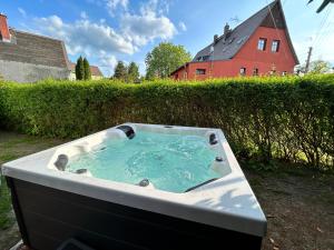 a bath tub in a yard with a red house at Maisonette-FeWo Fritz mit Infrarotsauna in Großschönau