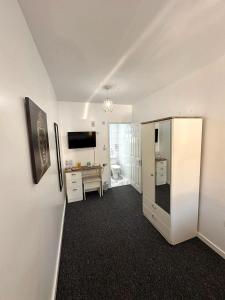 een kamer met een koelkast en een bureau. bij Newmarket Road Studios and Suites By Tas Accommodations in Cambridge