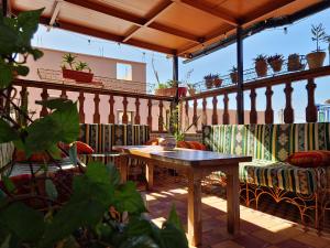 a patio with a table and chairs on a balcony at Surf hostel Morocco in Tamraght Ouzdar