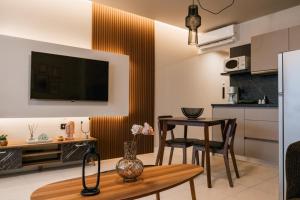 a kitchen and living room with a table and a television at Urban Style Suite in Alexandroupoli