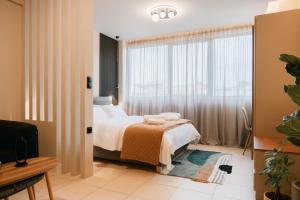 a bedroom with a bed and a large window at Urban Style Suite in Alexandroupoli
