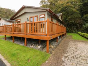 a house with a large deck on a yard at 16 Heritage Park in Narberth