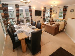 a dining room and living room with a table and chairs at 16 Heritage Park in Narberth