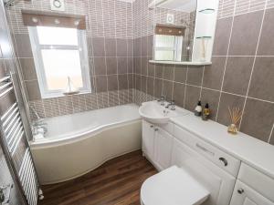 a bathroom with a tub and a sink and a toilet at 16 Heritage Park in Narberth +23 photos