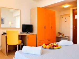 プントーネ・ディ・スカルリーノにあるPFA Hotel La Darsena - Follonicaのテーブルとフルーツの盛り合わせが備わる部屋