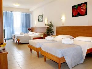 una habitación de hotel con 4 camas en una habitación en PFA Hotel La Darsena - Follonica, en Puntone di Scarlino